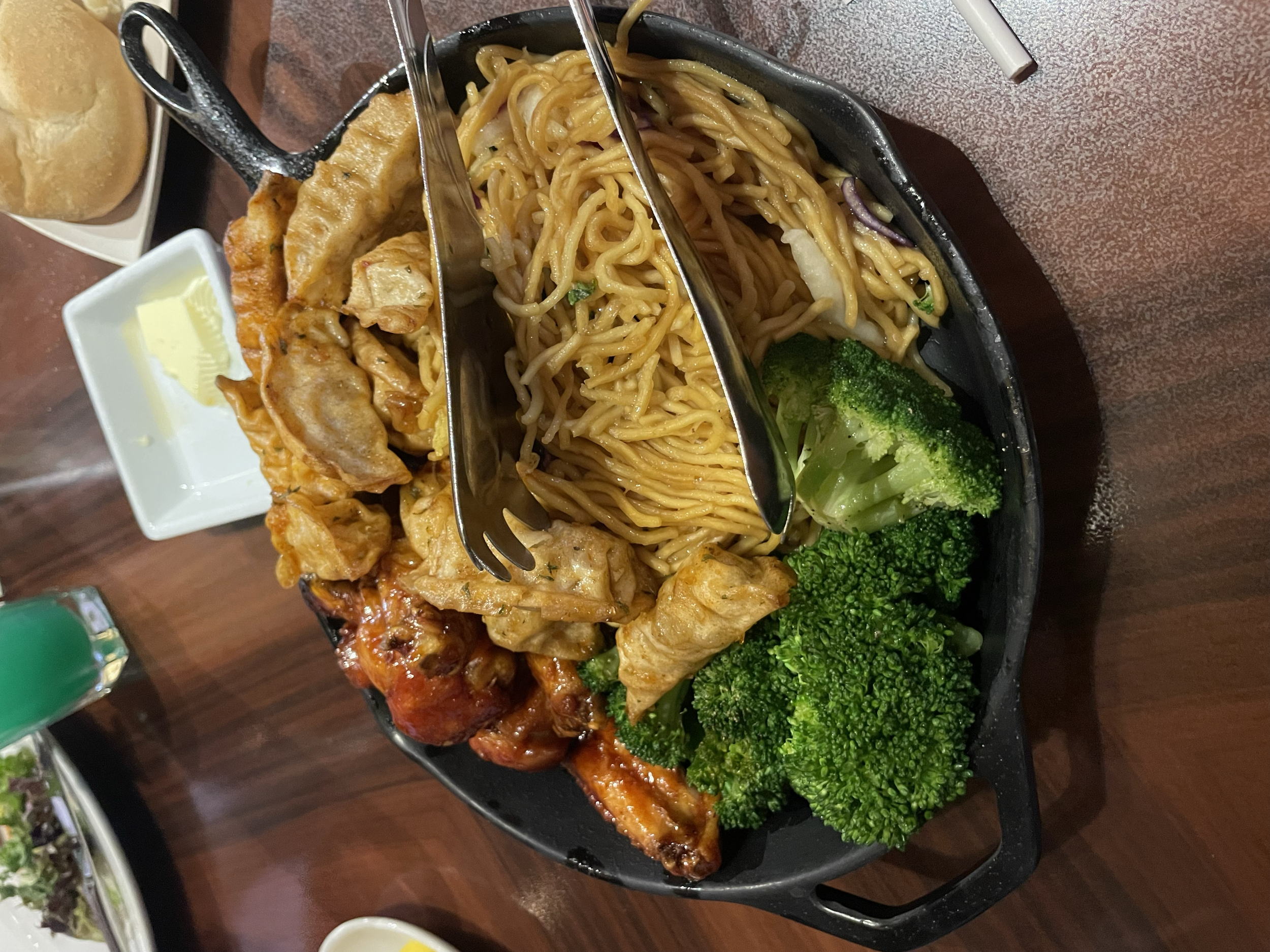 'Ohana Dinner Skillet - Honey-Coriander Chicken Wings, Pork Dumplings tossed in Garlic-Chili Sauce, 'Ohana Noodles, and Roasted Seasonal Vegetables.
