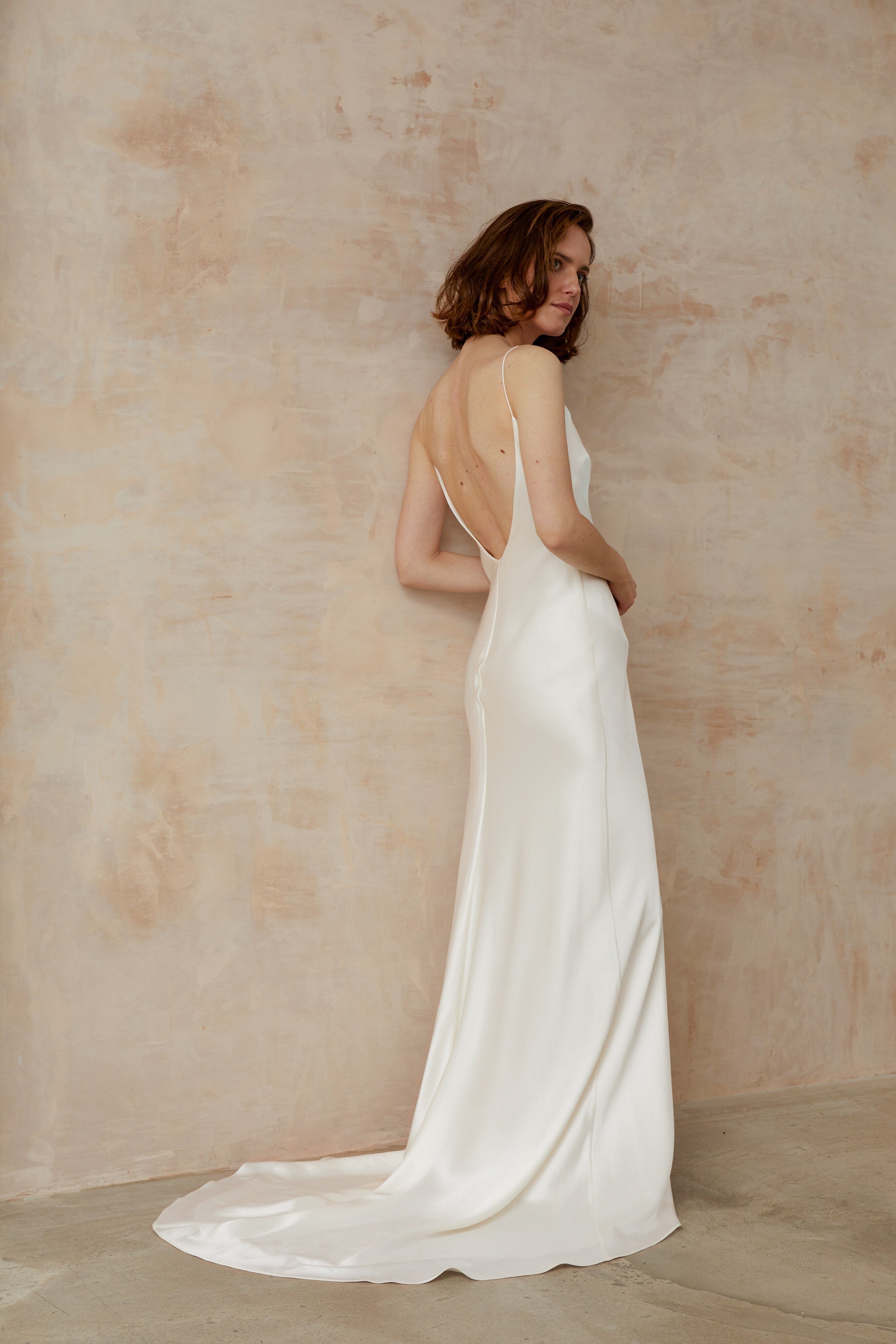 simple elegant ivory silk wedding dress worn by sleek modern woman