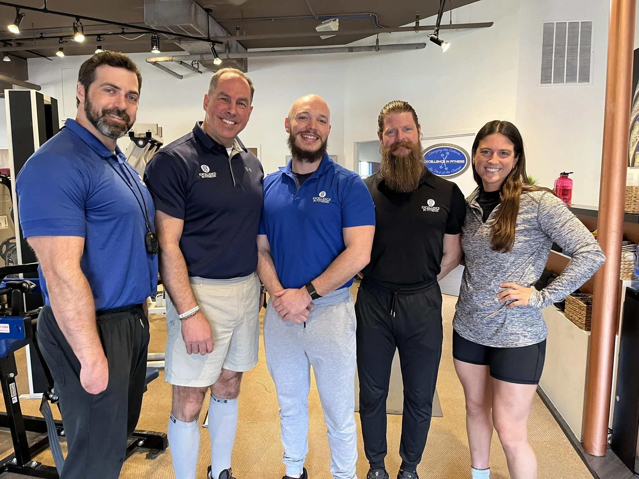 The coaching team at Excellence In Fitness collaborating to help clients achieve their health and fitness goals