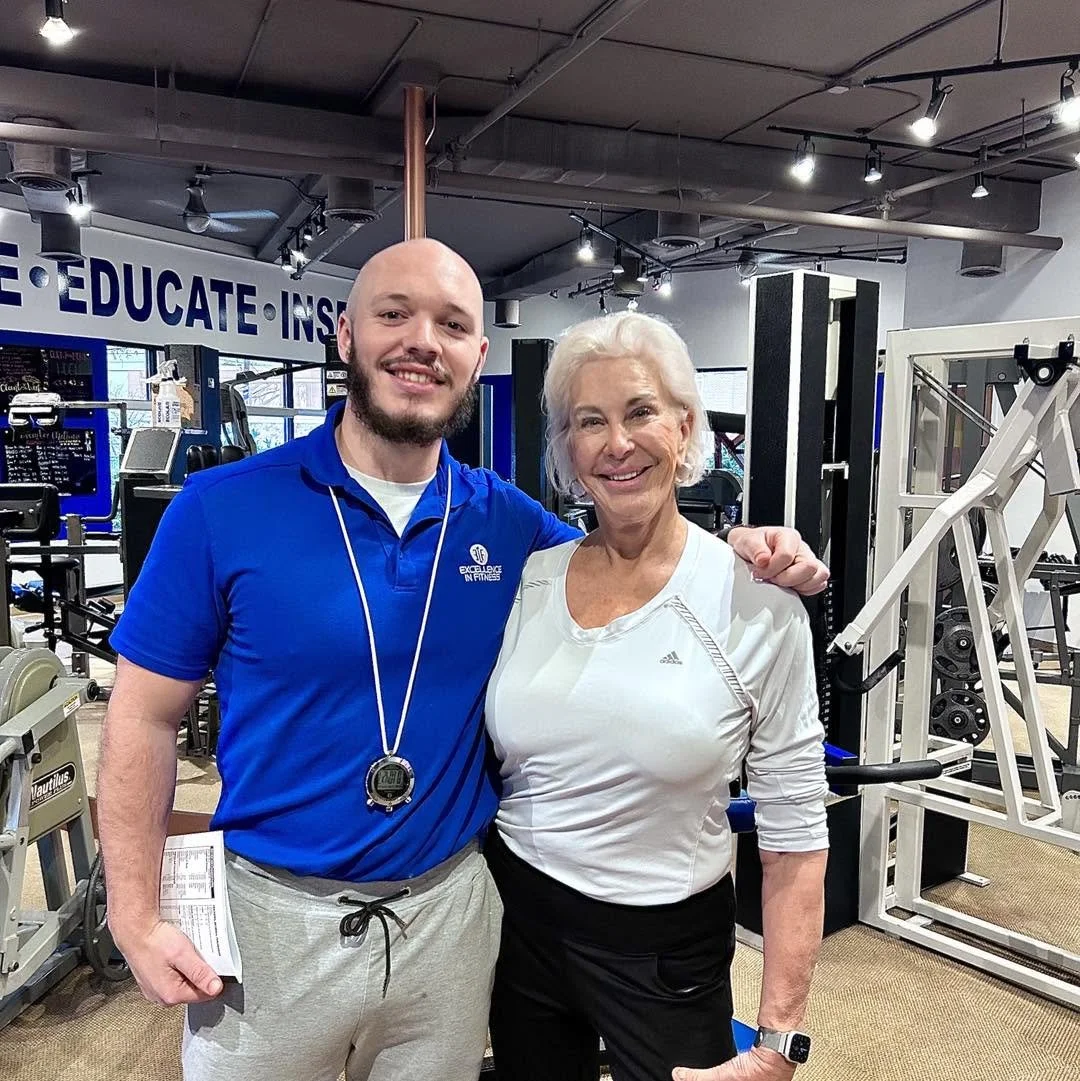 Personal trainer providing one-on-one coaching to help a client build strength and confidence at Excellence In Fitness.