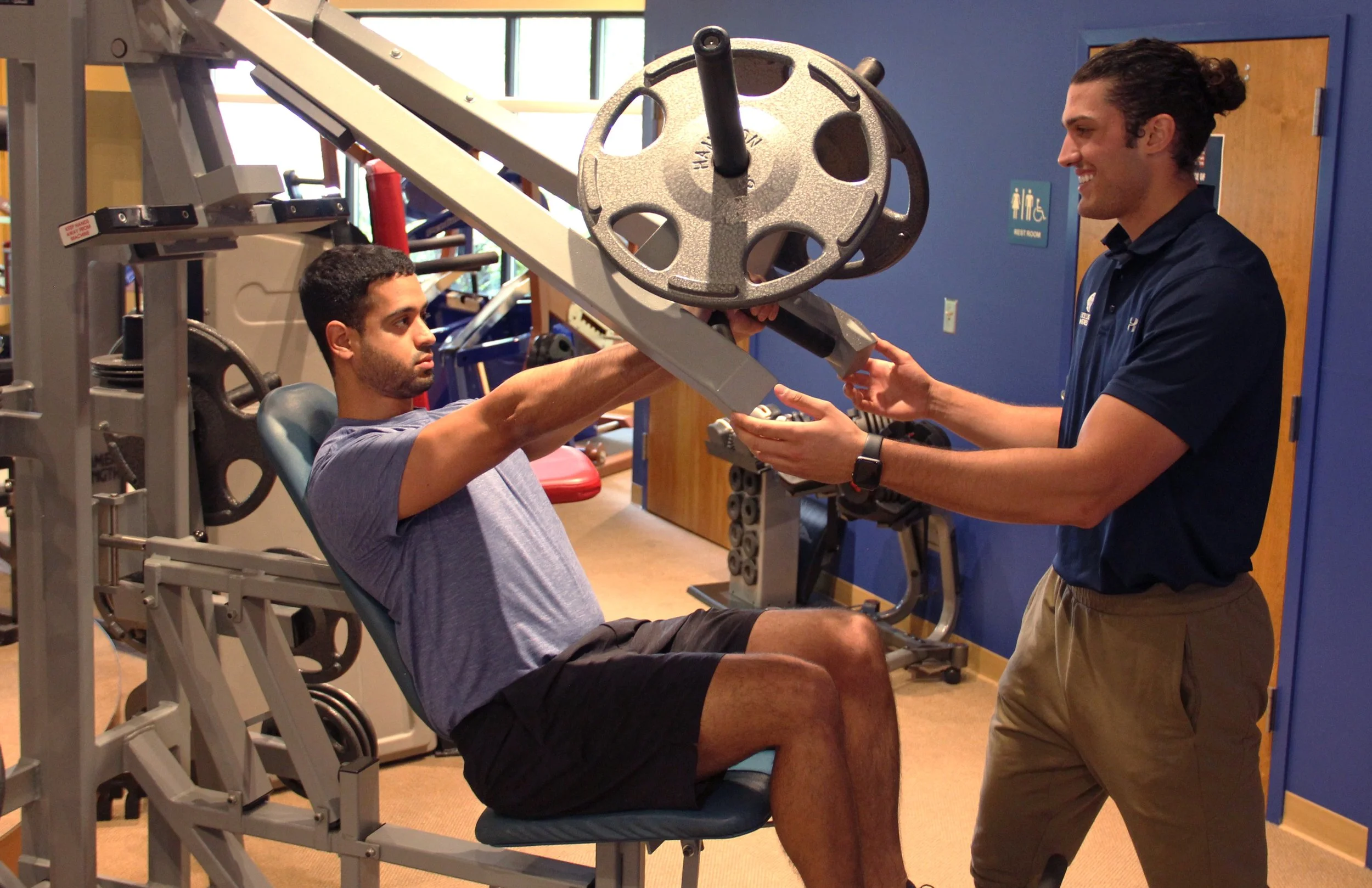 Exercise science professional teaching proper strength training technique during a personal training session