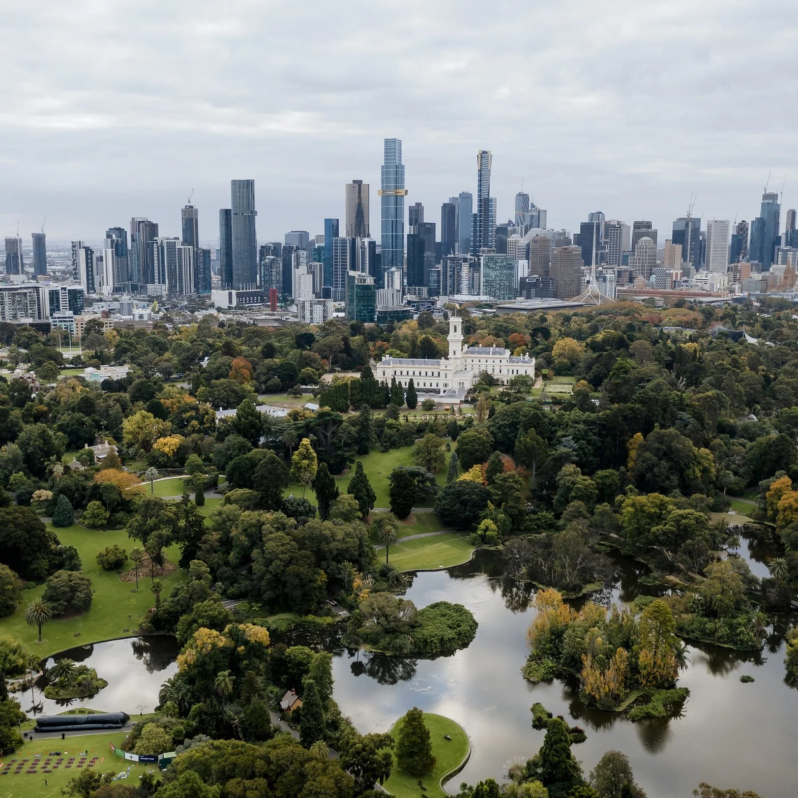 Aerial view of the iconic XXXX Brewery in Milton, Brisbane. The large red-brick industrial building features the “Milton Brewery” signage, a cartoon character holding a beer, and prominent XXXX branding on the rooftop and beer tanks.