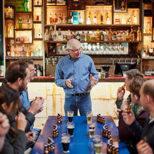 Aerial view of the iconic XXXX Brewery in Milton, Brisbane. The large red-brick industrial building features the “Milton Brewery” signage, a cartoon character holding a beer, and prominent XXXX branding on the rooftop and beer tanks.