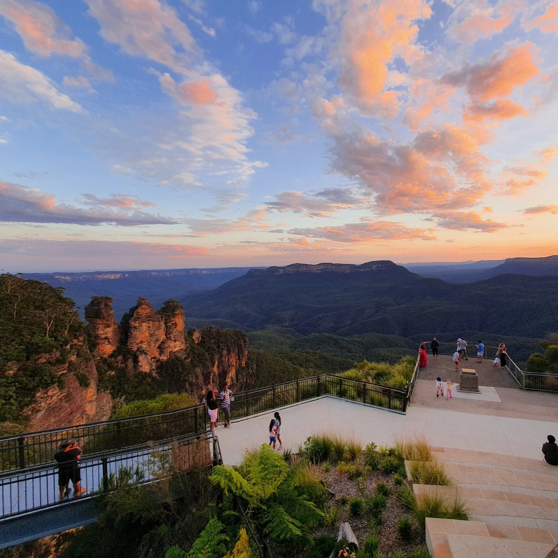 A walking trail with a blue mountain in the background under a sky with clouds