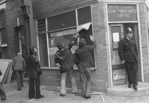 Workmen boarding up the South London Gay Community Centre after the eviction with a gormless looking copper keeping guard.