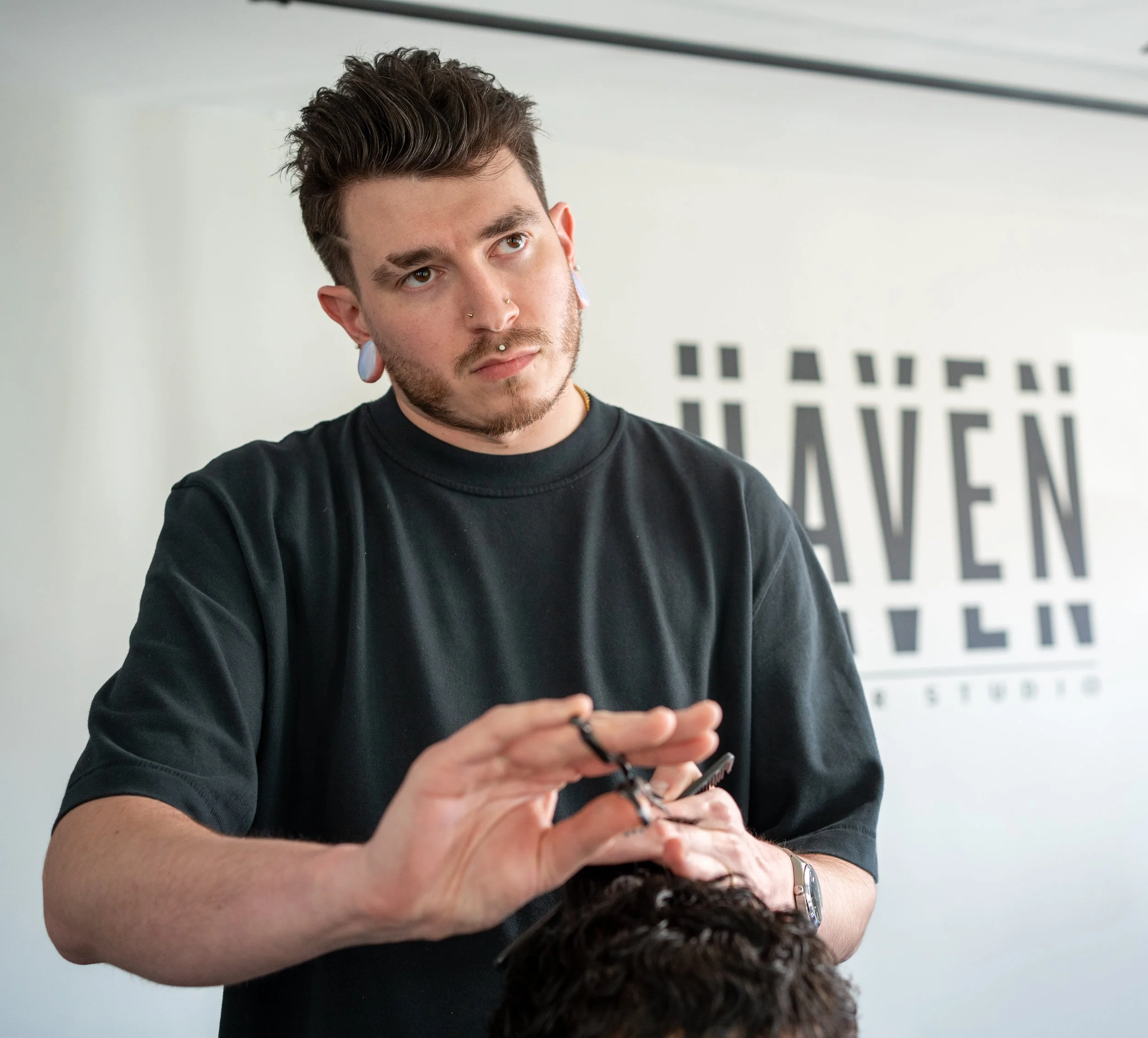 Haven barber Brandon scissor cutting a client's hair at Haven Barber Studio in Wilmington, MA