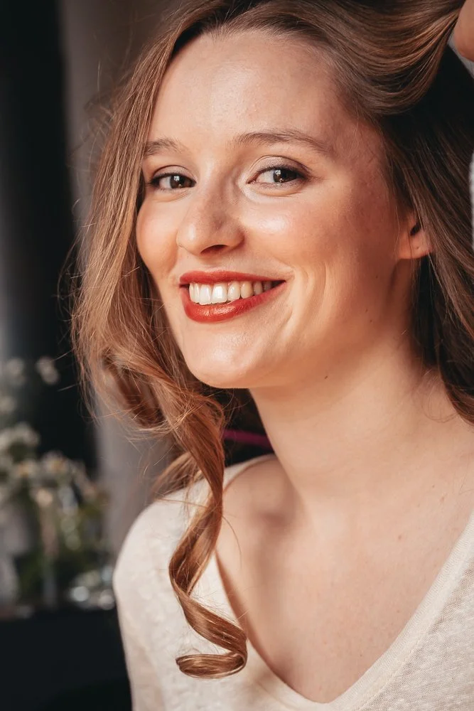 hübsche braut lächelt in die Kamera. Die Haare fallen teilweise ins Gesicht