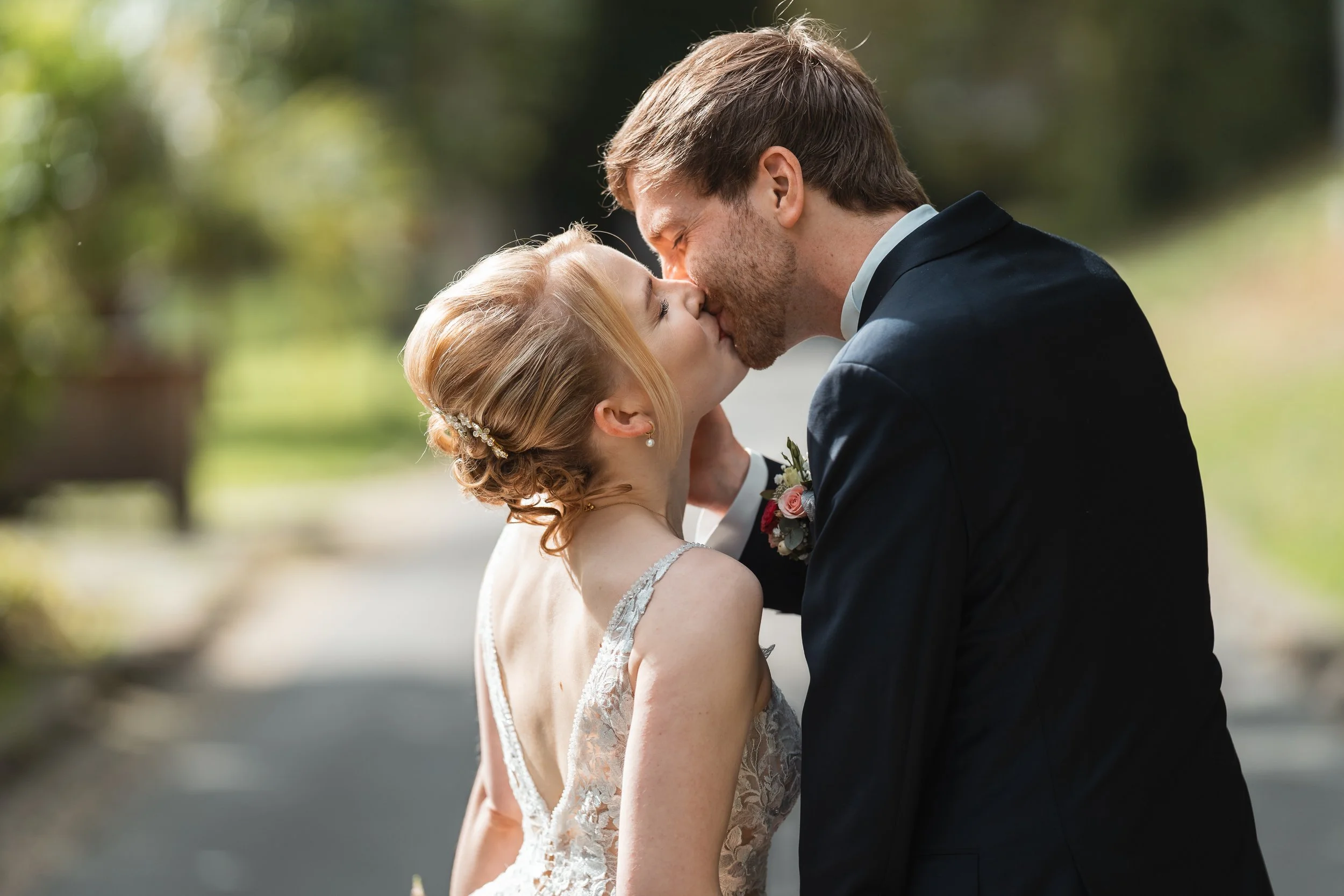 Ein frisch verheiratetes Paar küsst sich bei sonnigem Wetter im Freien. Bad Wildungen Hochzeit in Burg Friedrichstein. Hochzeitsfotograf Frankfurt am Main