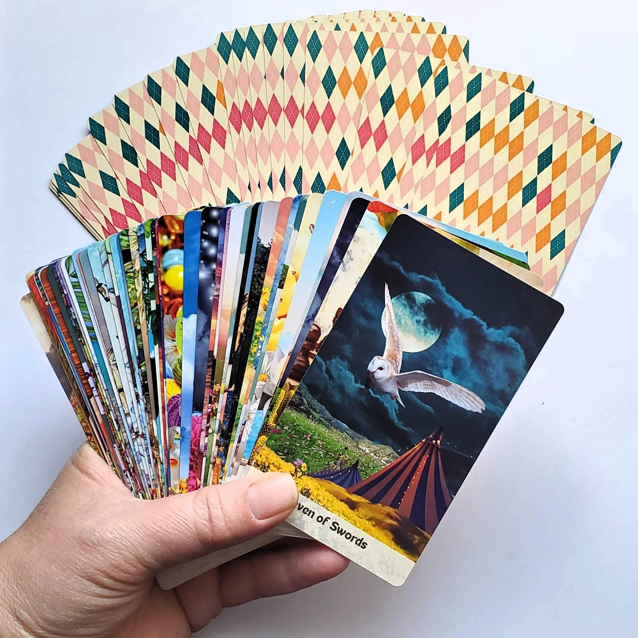 How Did I Get Here Tarot cards fanned in hand showing vibrant collage artwork — indie tarot deck by S.G. Stasi Designs