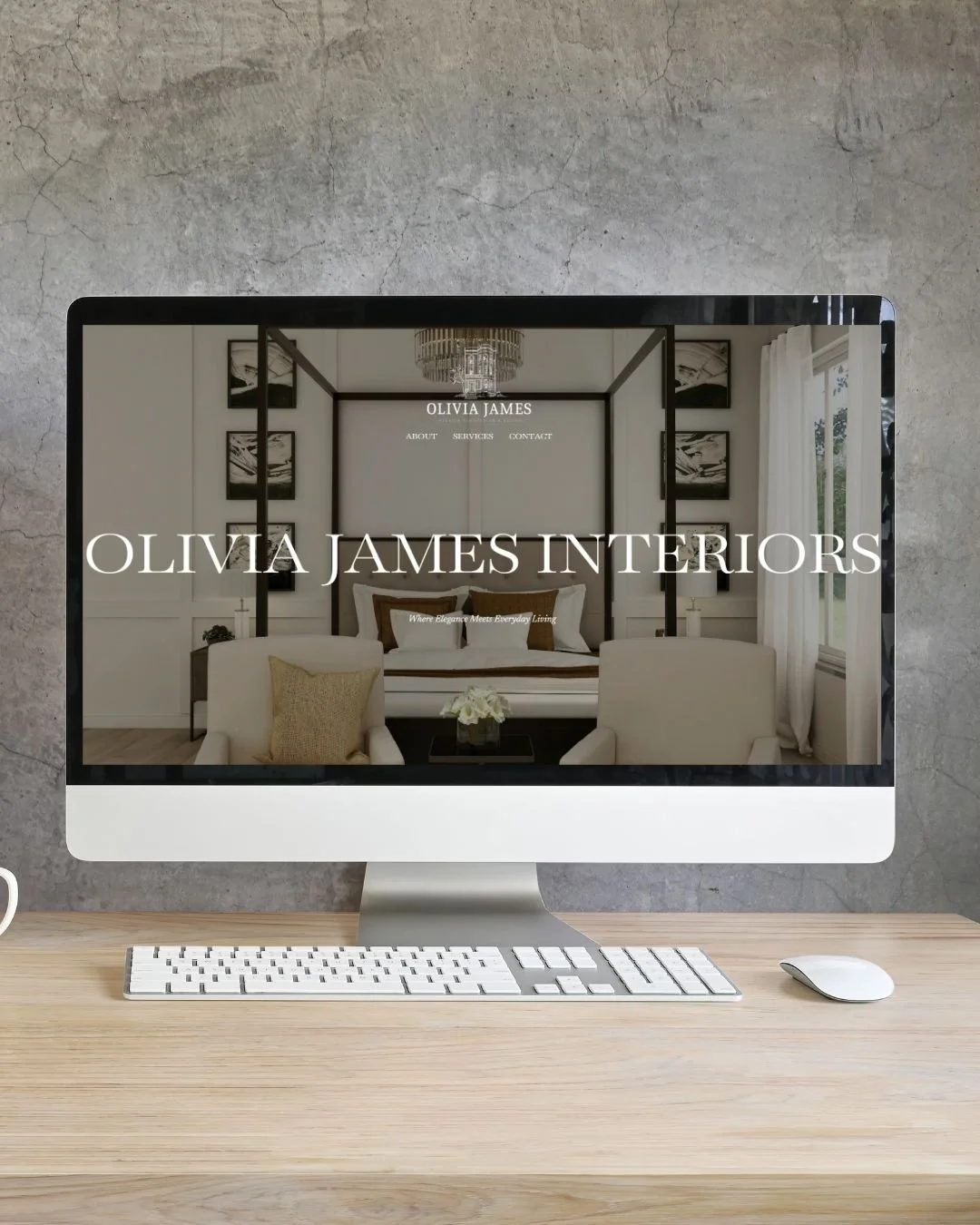 Computer monitor displaying a website for Olivia James Interiors, featuring a modern bedroom interior with white walls, a chandelier, and large windows with drapes.