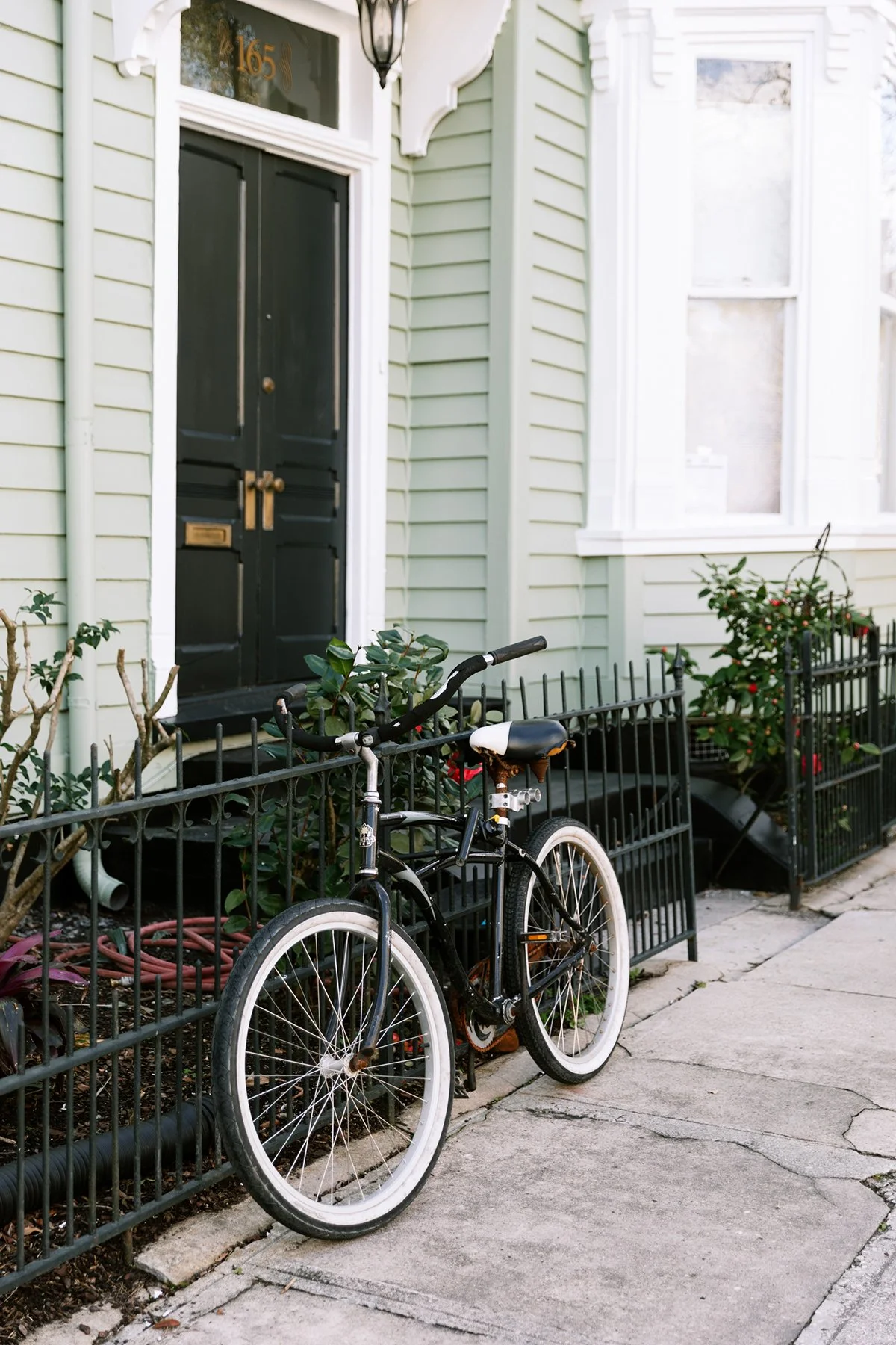 bicycle leaning against a fence in front of a house