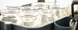 Empty glass jars on a tray with a straw visible on the right side.