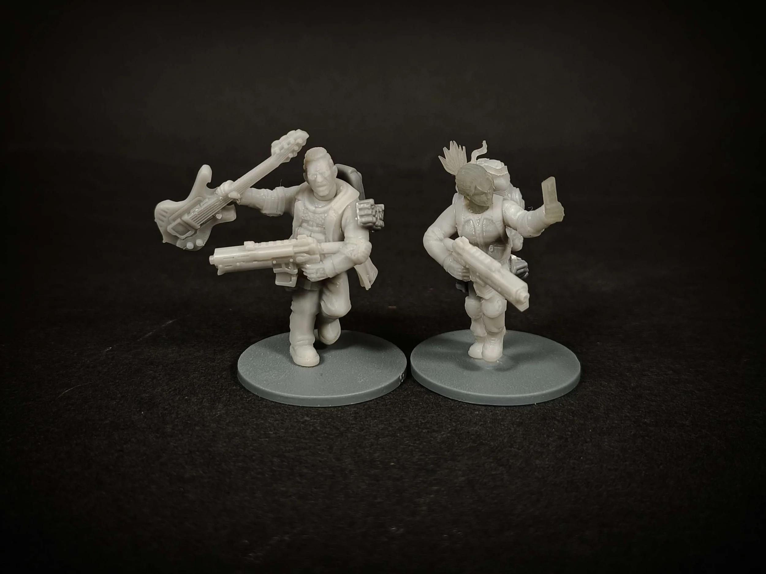 Two custome made miniature figurines, one holding a guitar and the mobile phone