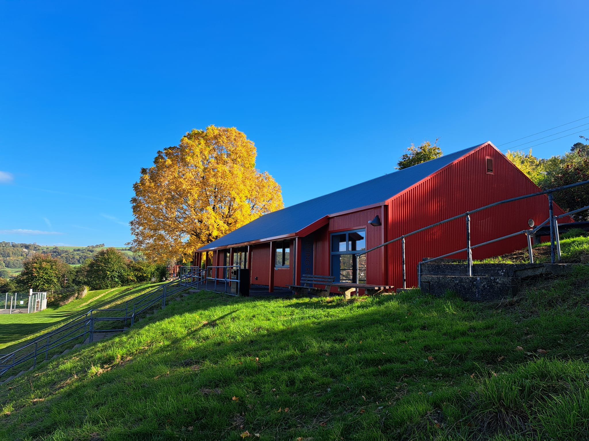 Rodborough Community Hall new bright red metal elevation