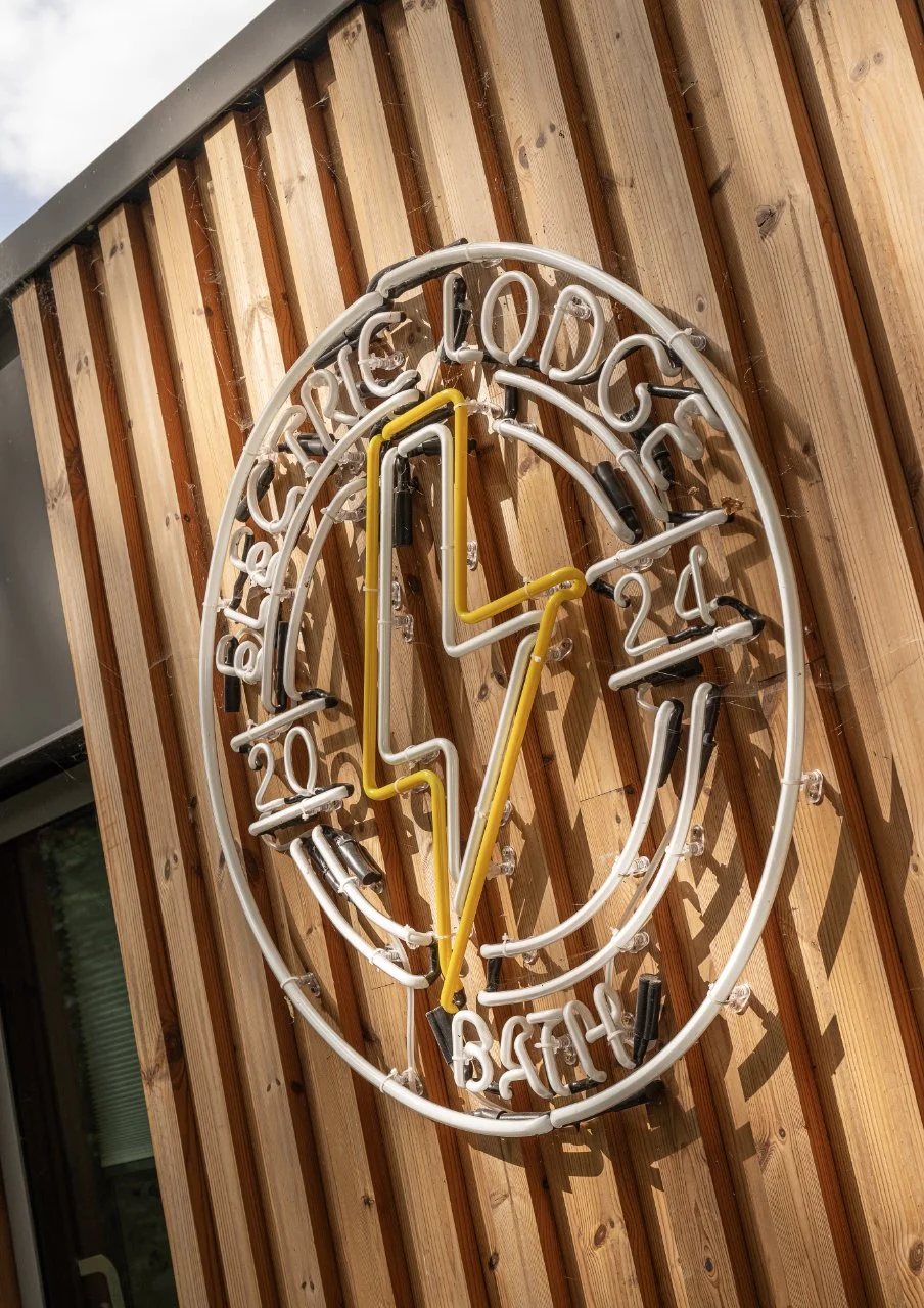 Illuminated graphic signage on timber boarded front elevation