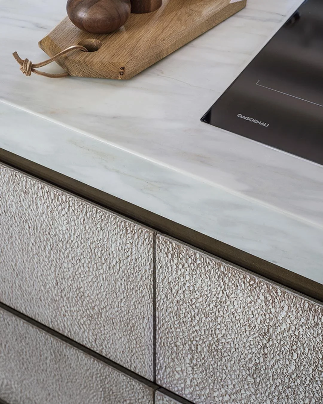 This kitchen brings together rich textures and thoughtful design. The brass finger rails add a gentle warmth, while the handleless shark-nose doors keep everything feeling clean and refined - a space that&rsquo;s easy to live in and even easier to lo