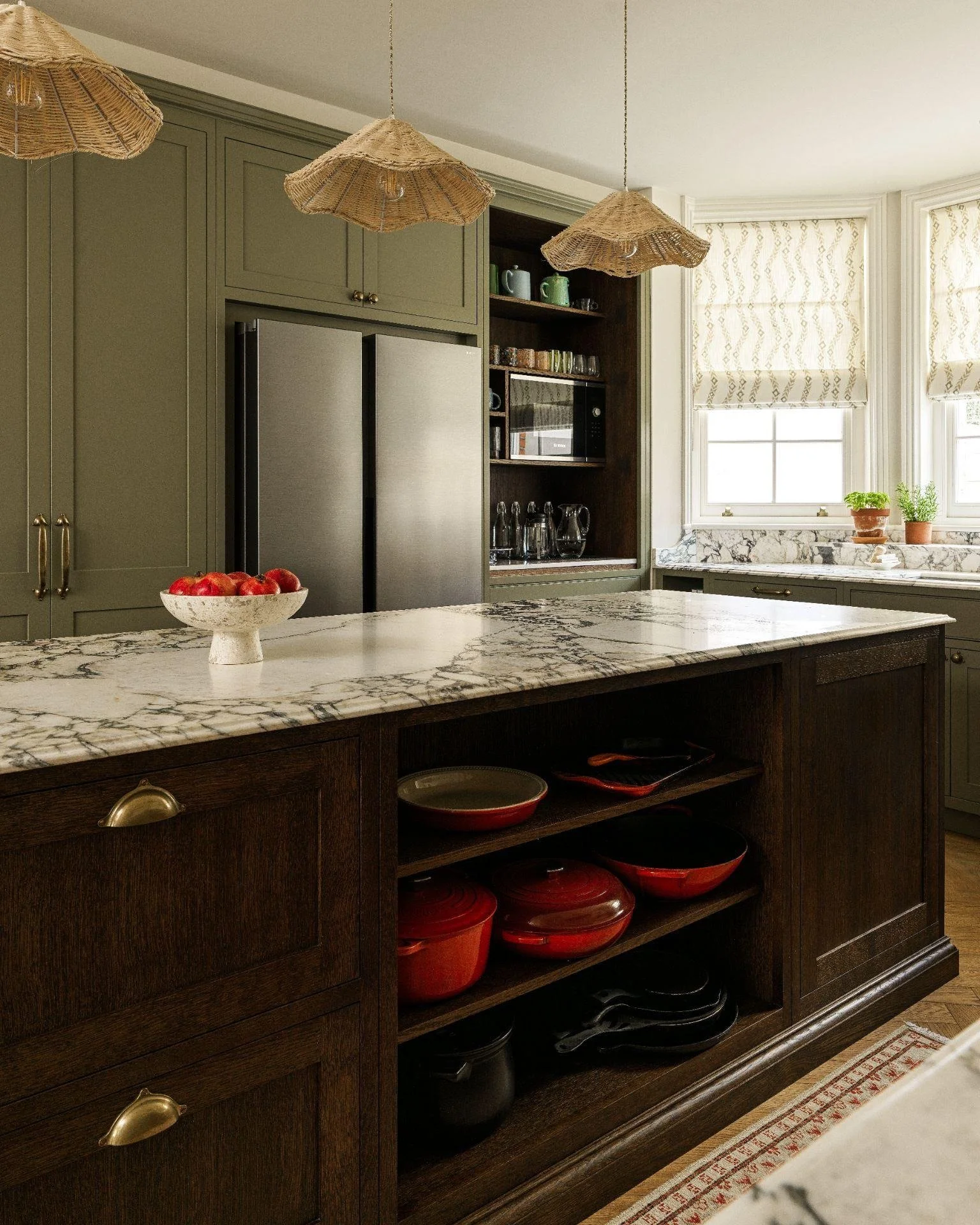 This island is where everything comes together - morning coffee, quick lunches, weekend baking, and late-night chats. The open oak shelving keeps the client&rsquo;s Le Creuset collection on show, while deep drawers with peg inserts make it easy to gr