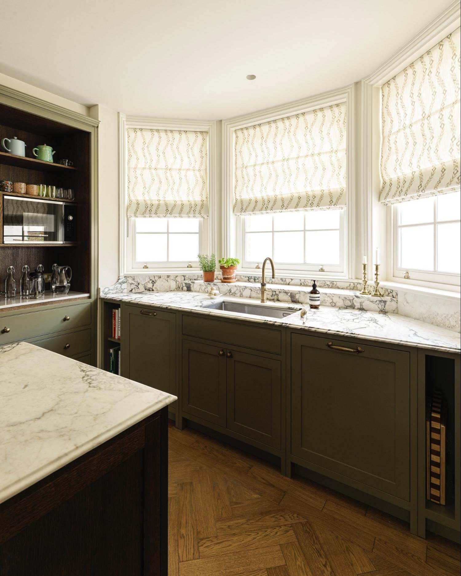 Morning light spills across the marble here, catching the brass tap as water runs for that first coffee (or a quick rinse of fruit). The workstation keeps everything moving easily - from prepping and chopping to tidying up after dinner. Chopping boar