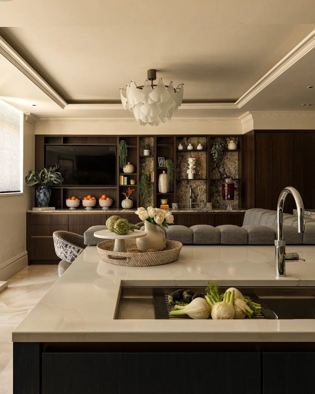 The breakfast bar naturally sits at the centre of this kitchen, used just as much for prep as it is for pulling up a stool and catching up with family. Made from stone, it gives the kitchen a solid, sculpted feel without ever getting in the way of ho