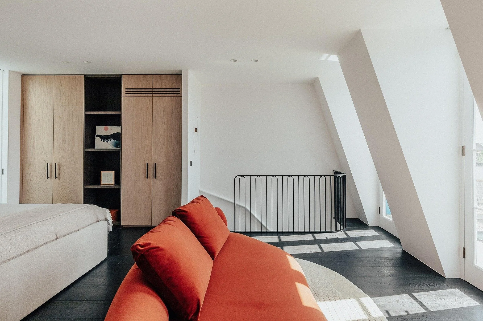 Oak cabinetry brings warmth and character to the bedroom, with wardrobes carefully shaped to support our client&rsquo;s daily routines effortlessly. Finished in a light, bleached stain over crown-cut oak, the doors maintain a soft, natural feel, whil