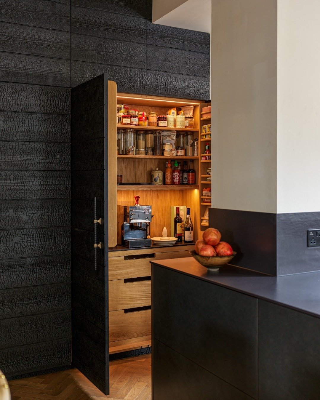Tucked neatly into the kitchen, this larder is designed around our client&rsquo;s small, personal habits. Soft lighting gives the space a gentle presence, while the shelves keep coffee beans, chocolate bars, and favourite late-night snacks organised 