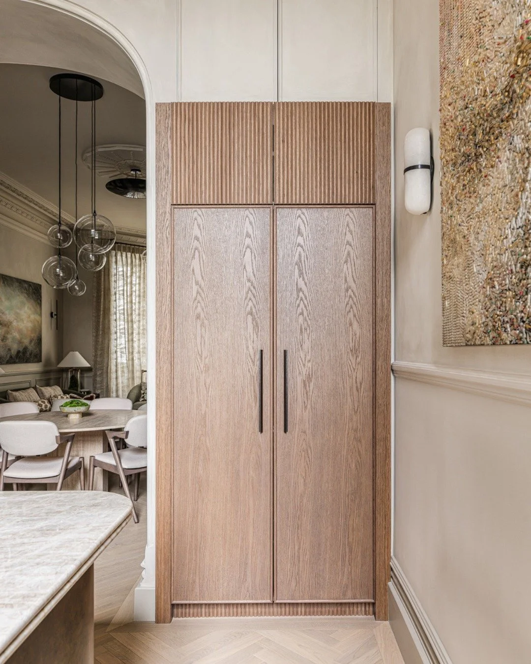 Inside the double breakfast cabinet, cups and a kettle are set ready so coffee can be poured before the rest of the house is fully awake. The corner pull-out keeps juices tucked neatly to one side, easy to reach when breakfast turns into brunch, whil