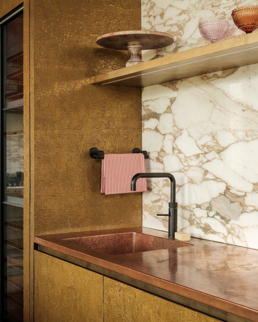Along the outer cabinetry, a warmer tone helps frame the space. 
The Shou Sugi Ban panel is finished here in metallic brass, bringing richness to the room and creating a natural contrast with the surrounding materials.

@quookeruk
@inspiredmetalltd
P