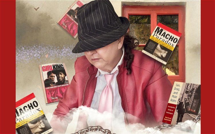 A woman's in a red jack and pink tie has her face obscured by a hat. Around her fly books called The Macho Paradox and GirlKing