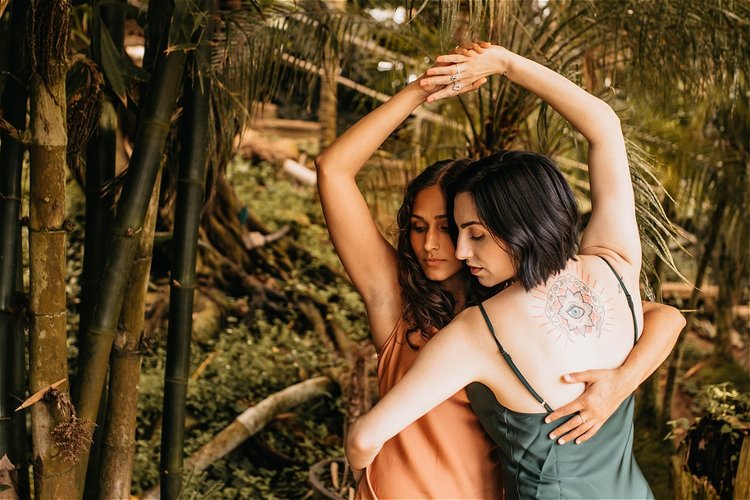 Two women dancing in embrace, hands joined above heads