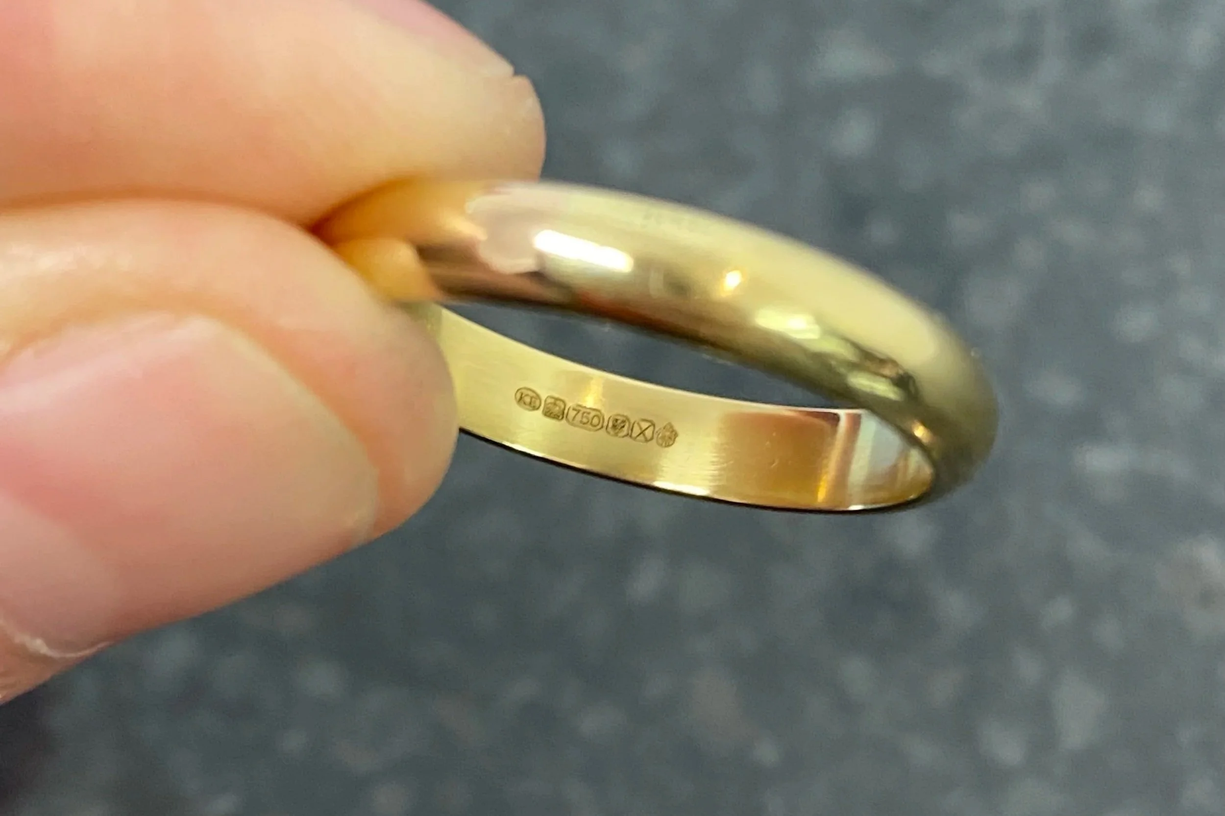 Close-up of UK gold hallmark showing sponsor's mark and purity stamp
