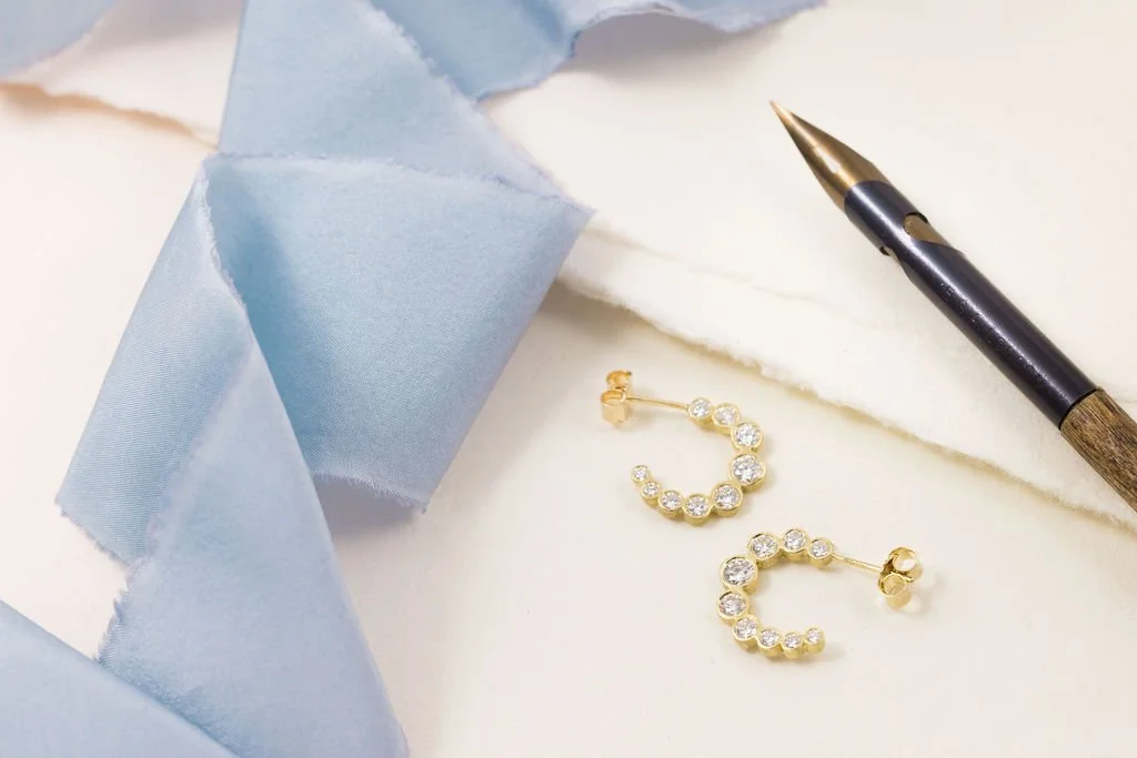 Yellow gold crescent hoop earrings set with graduated brilliant-cut lab-grown diamonds handcrafted by Katherine Elder in her North London studio