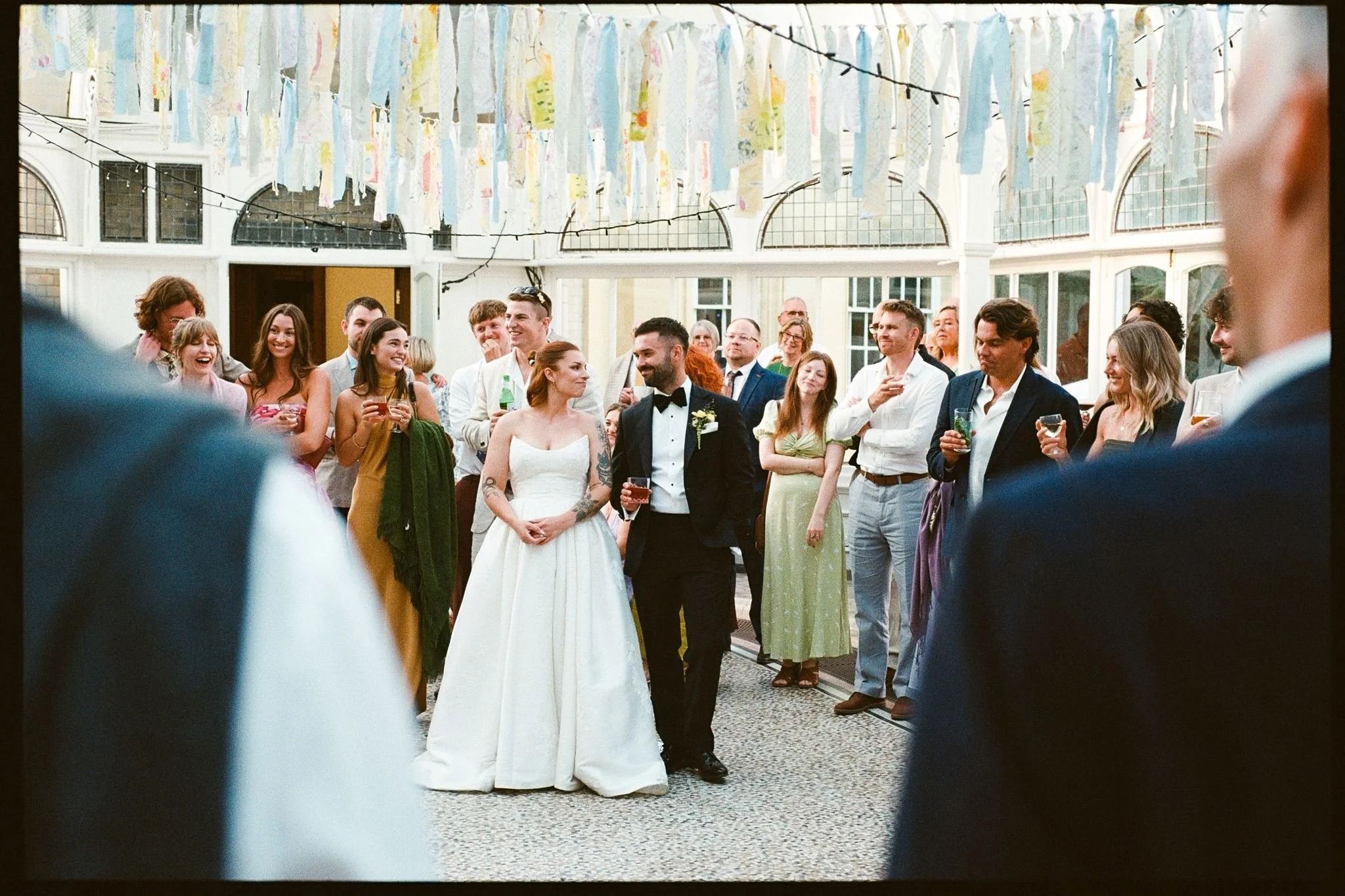 Bride and groom amongst wedding crowd at Carrow House, Norwich, on 35mm film.