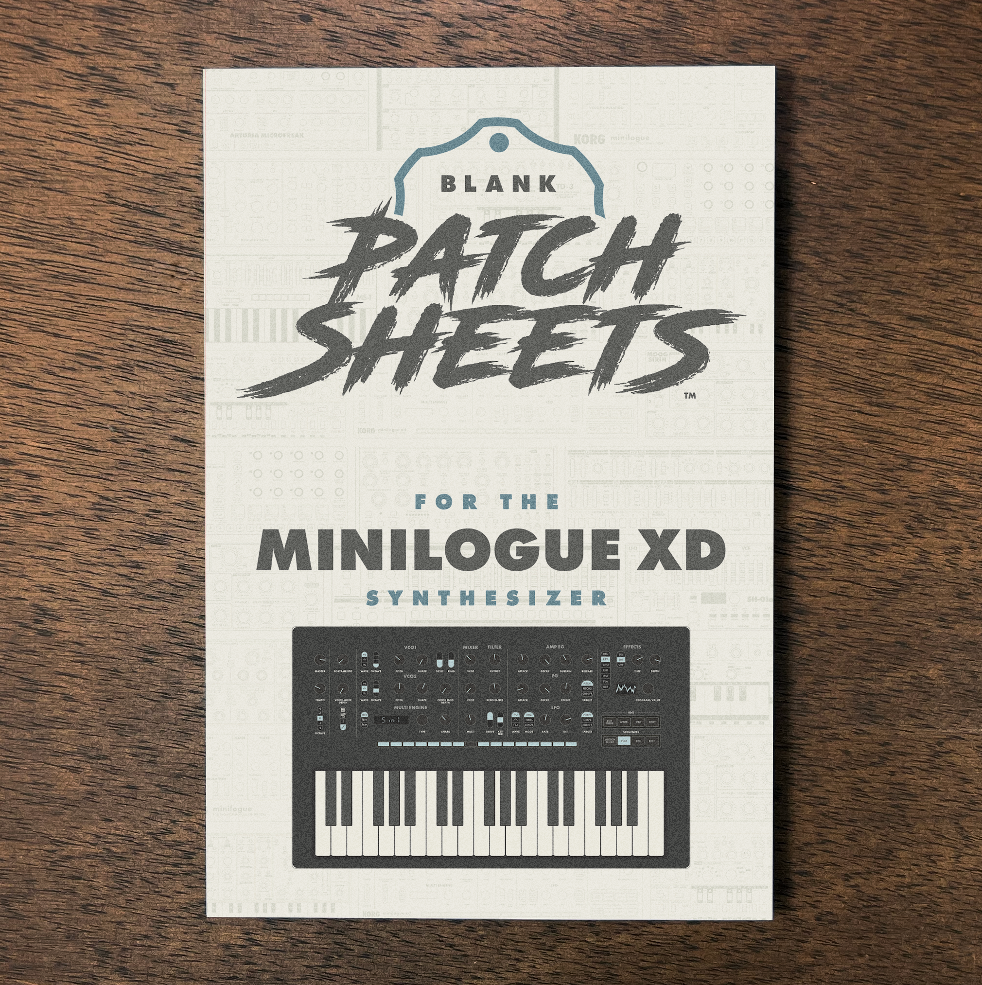 Packaging for blank patch sheets designed for the MiniLogue XD synthesizer, with a picture of the synthesizer on the front, placed on a wooden surface.