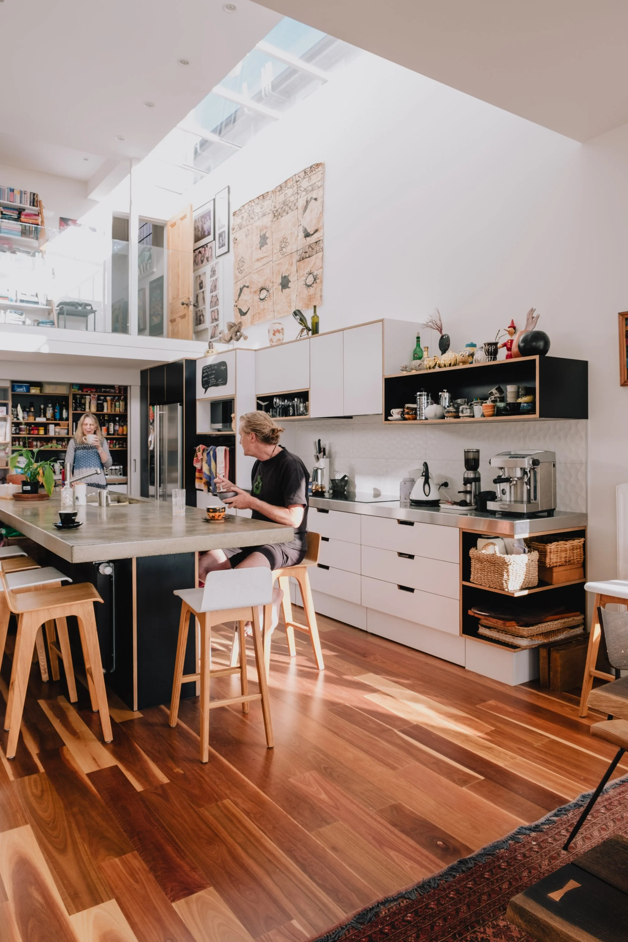 Light-filled open-plan kitchen and living space in Talavera Terrace renovation, featuring skylights, timber detailing, and modern villa interior design by First Light Studio in Wellington.