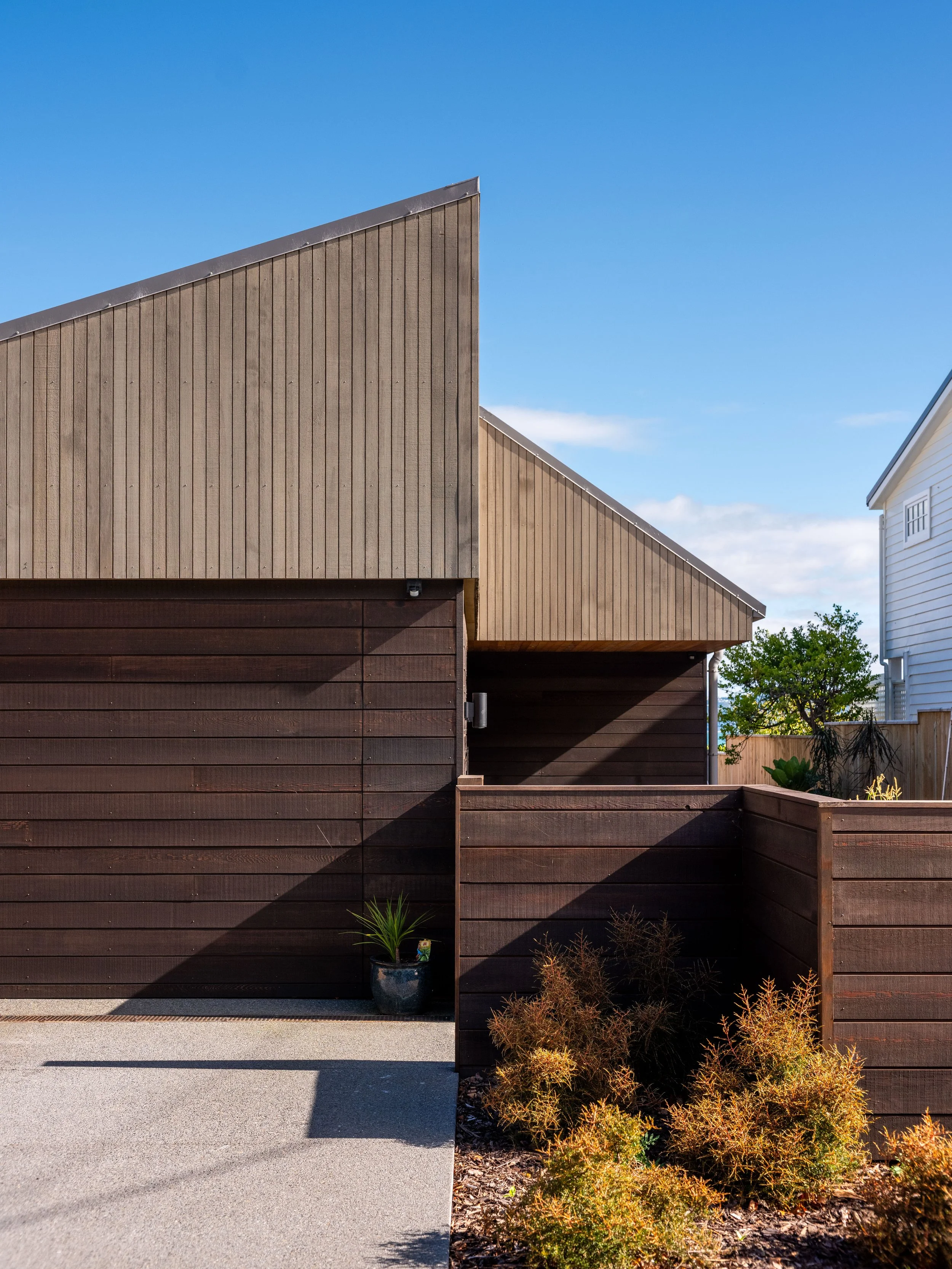 Eastbourne House viewed from the street, with its distinctive timber screen roof and dark timber cladding.