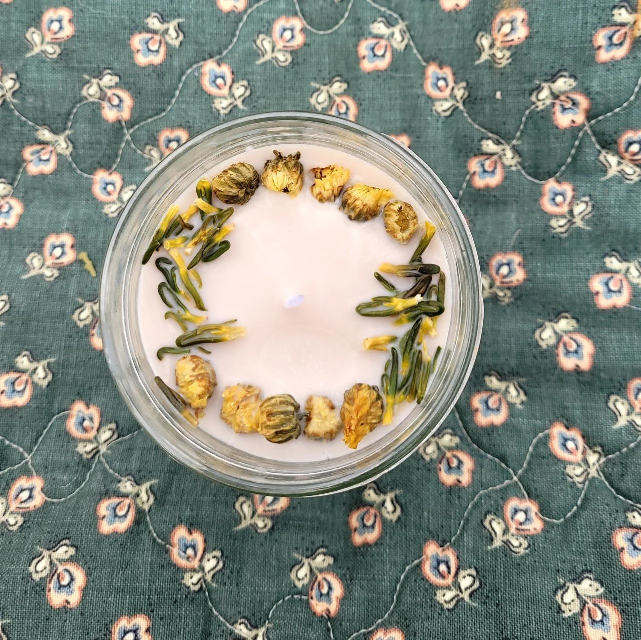 This candle is decorated in lotus and money plant flowers and smells like spice cake!
