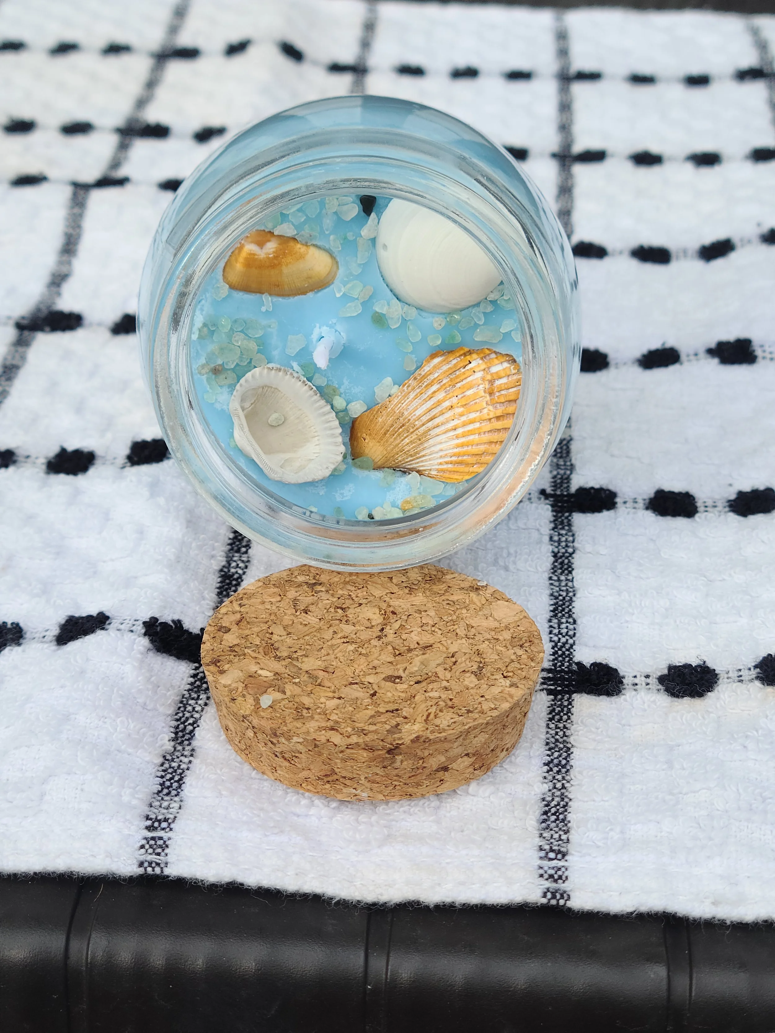 This candle is decorated in crystal chips and shells.  It smells like coconut and other wonderful aromas that will bring your mood right back to the warm days of summer and toes in the sand!