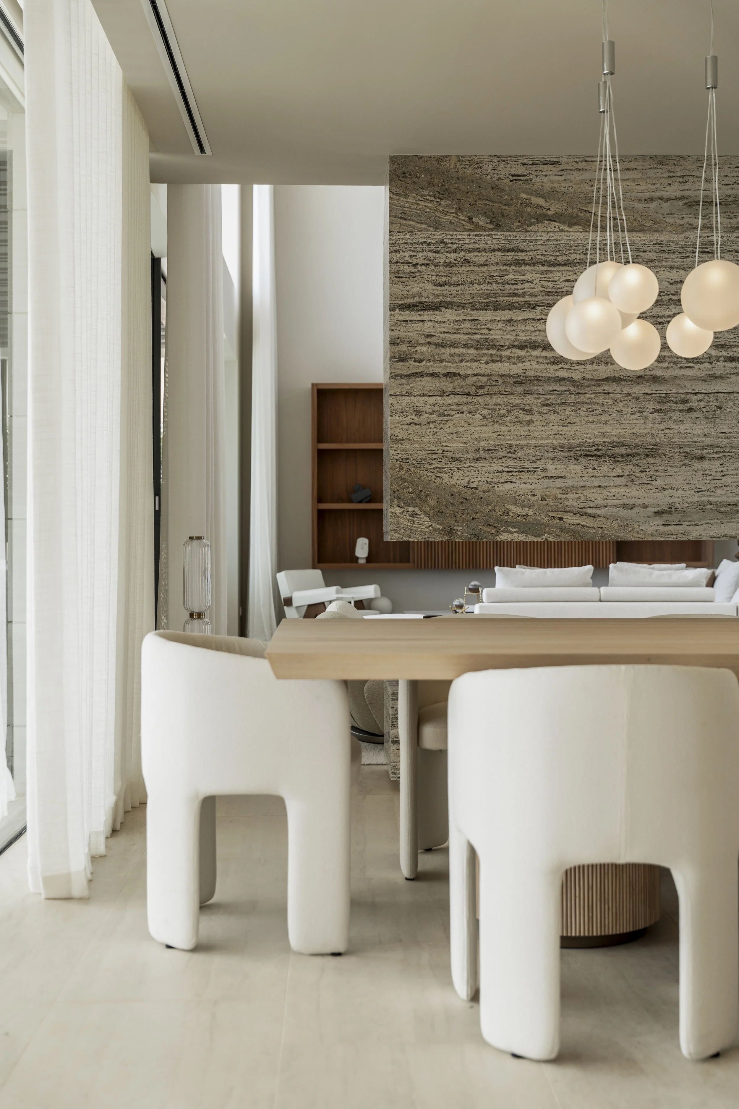 Niña abrazando un juguete de peluche en una habitación con espejo y cama.