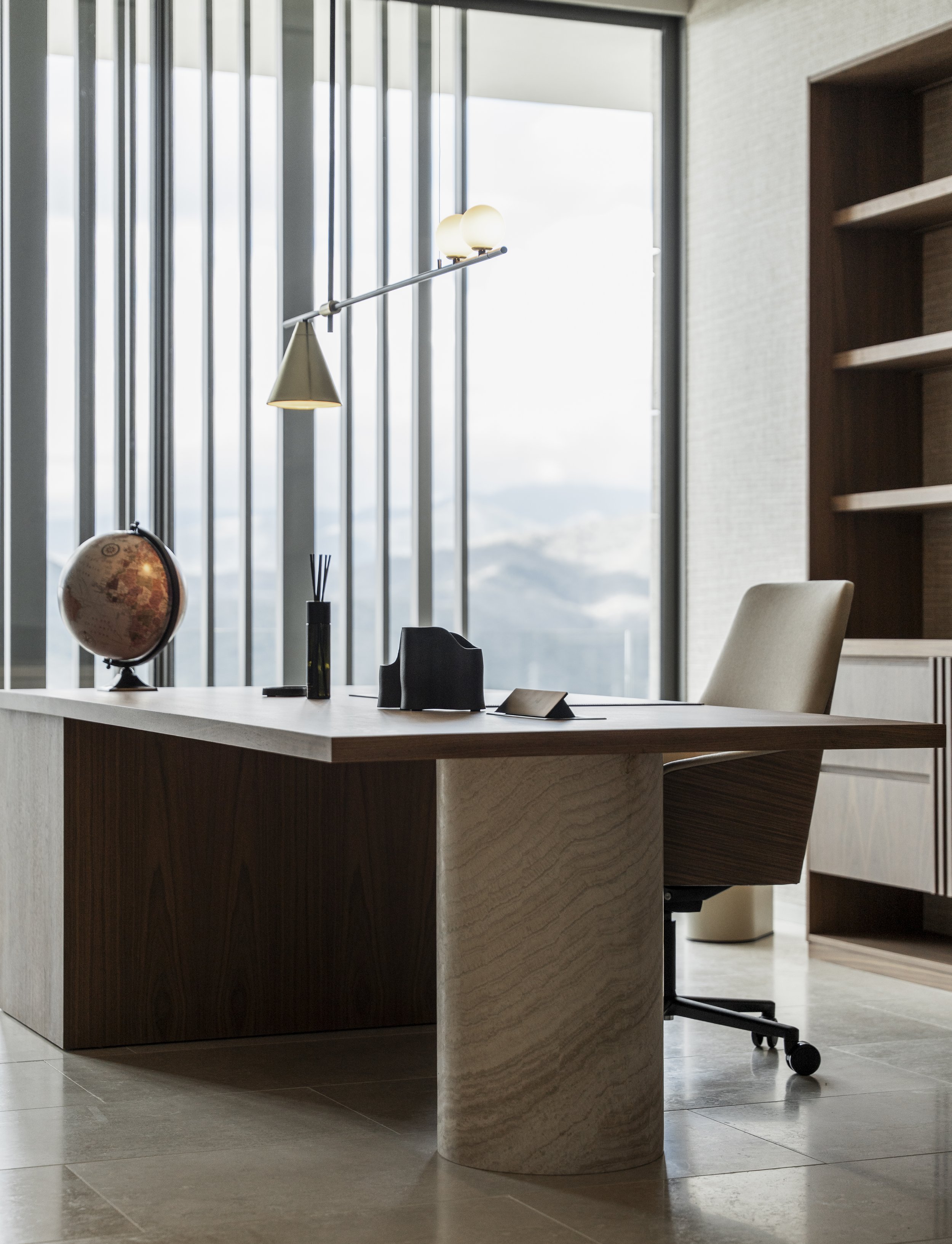 Niña abrazando un juguete de peluche en una habitación con espejo y cama.