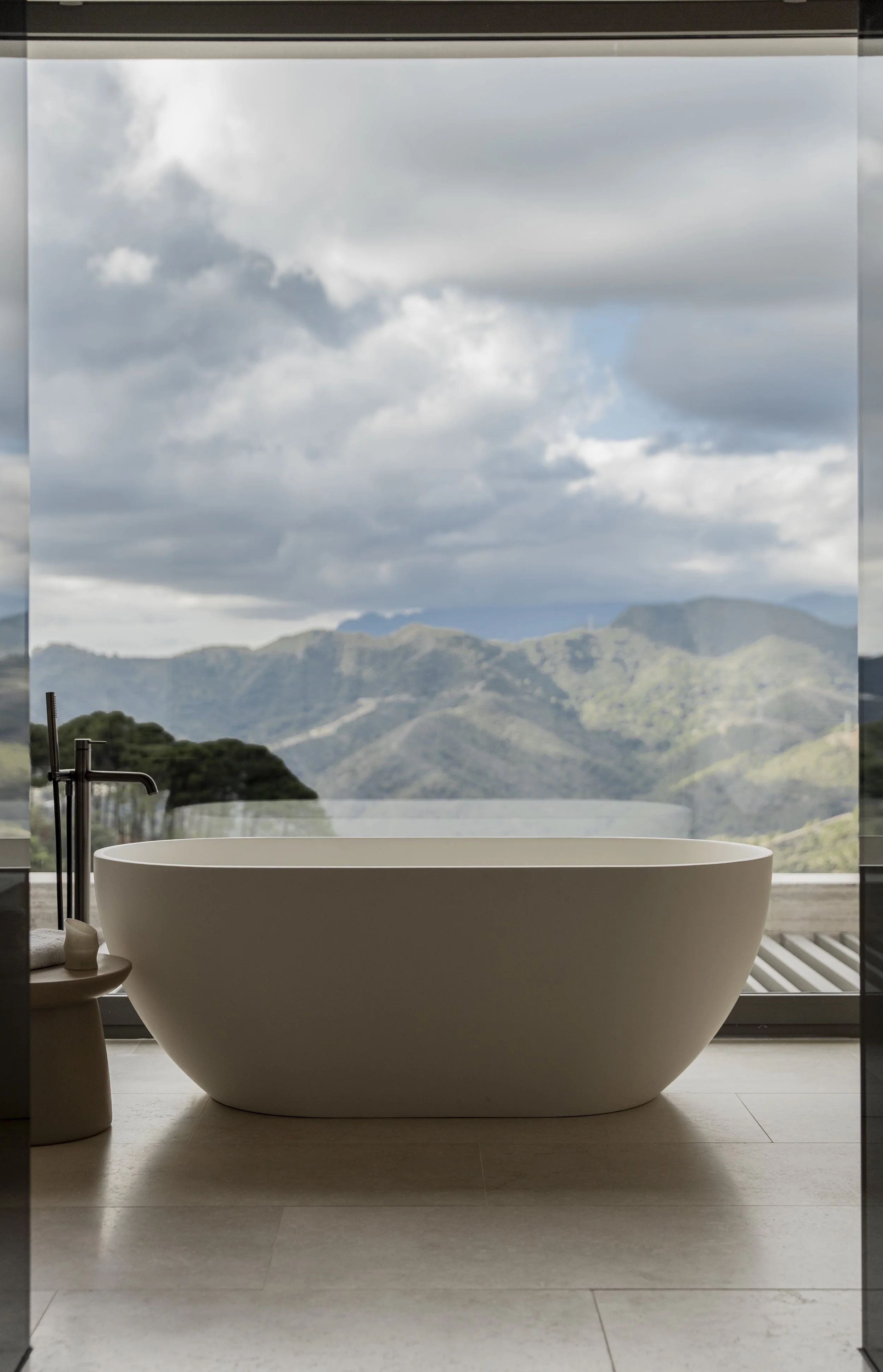 Mujer peinando a una niña pequeña sentada en un baño.