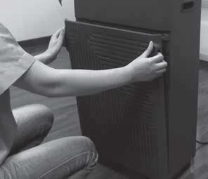 Opening the front panel of a portable electronic air purifier by its handle slots