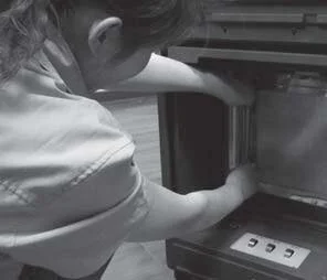 Reaching into the Photocatalytic chamber of a portable air purifier to replace a UV lamp