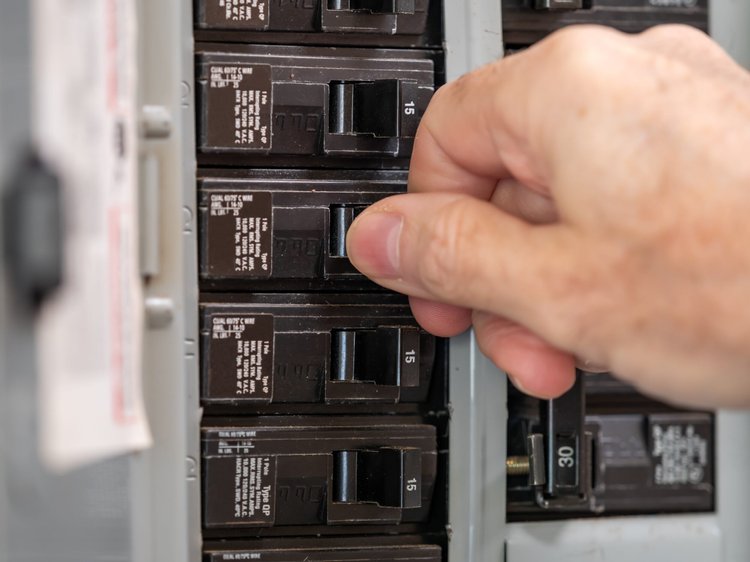 Hand switching a breaker in a home electrical panel