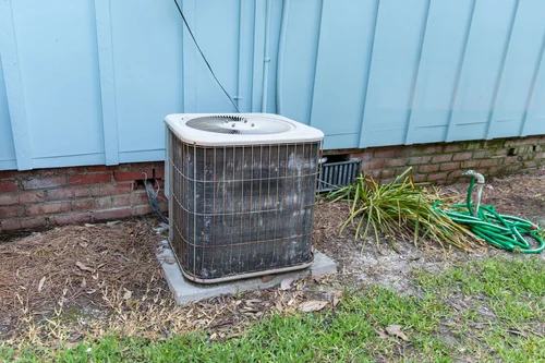 Outdoor air conditioner unit and its refrigerant lines beside a house