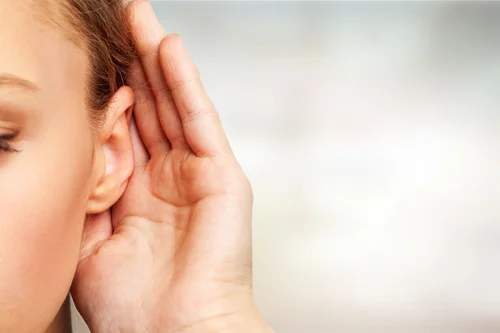 Person cupping a hand to one ear to listen