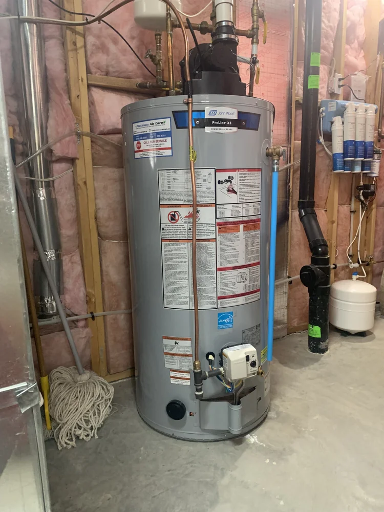John Wood ProLine XE tank water heater in a basement with a Platinum Air Care service sticker on the tank
