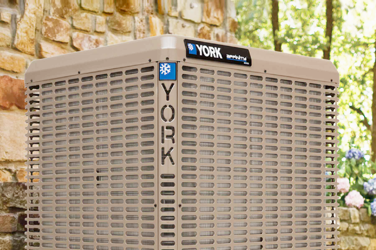 York Affinity central air conditioner, the outdoor unit with the York badge, beside a stone wall