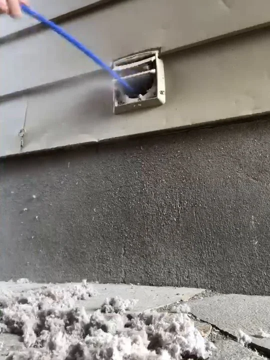 Lint blown out of one dryer vent and piled on the ground under the exterior vent hood, during a Platinum Air Care dryer vent cleaning