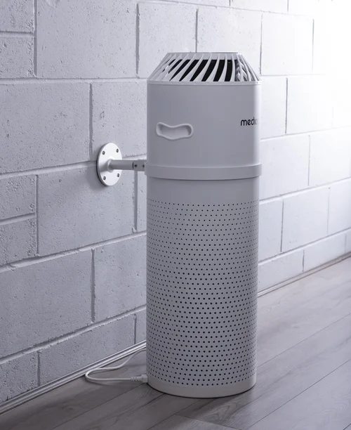 MedicAir air purifier held on a white brick wall by its wall bracket