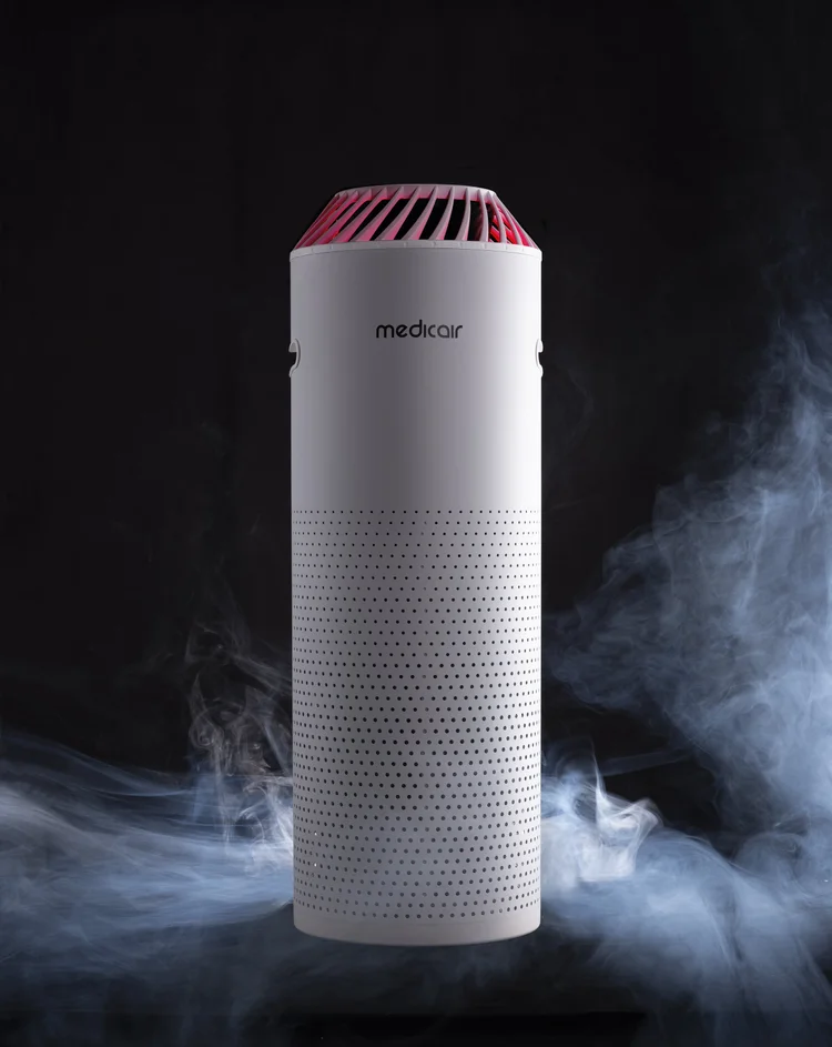 MedicAir air purifier standing in drifting smoke, its top vent lit red